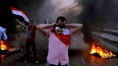 An Egyptian protester covers his face with his national flag during clashes between supporters of the Muslim Brotherhood and security forces in Cairo.