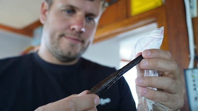 Underwater archaeologist Peter Moe Astrup with what is thought to be a simple tool found at the site. AP