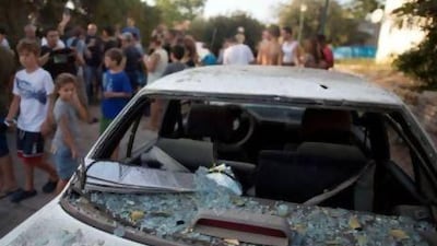 Israeli residents inspect the damage caused by a rocket fired from Lebanon into the Gesher Haziv kibbutz in northern Israel.