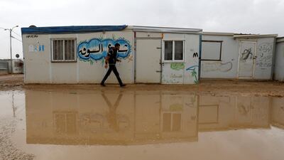A Syrian refugee walks during rainy weather at Al Zaatari refugee camp in the Jordanian city of Mafraq, near the border with Syria, on December 18, 2016. Muhammad Hamed / Reuters