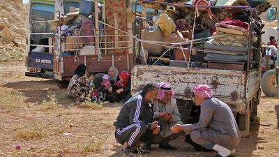 Syrian refugees gather next to their vehicles getting ready to cross into Syria from the eastern Lebanese border town of Arsal, Lebanon, on June 28, 2018. Stringer / AFP