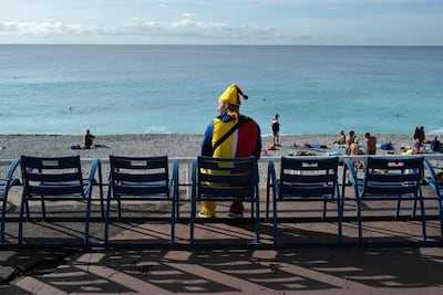 A man in colourful clothing sits out on the beach in the French rivieria city of Nice. AFP