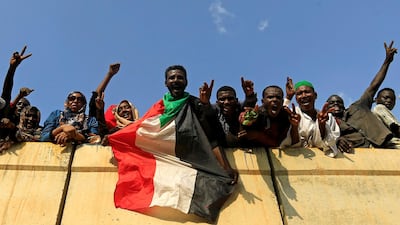 Sudanese wave the national flag in Khartoum on August 17, 2019 as they celebrate the signing of a deal that puts the country on a path democratic rule. Reuters