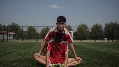 Students stretch following an under-14 training session at the Pyongyang International Football School. Ed Jones / AFP