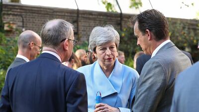 British prime minister Theresa May holds a bat in the garden of 10 Downing Street during the team reception. AFP