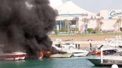 The yacht Riva burns in front of Marina Mall.