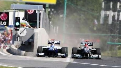Michael Schumacher, right, almost forces Rubens Barrichello into the pit wall, with Barrichello pushing back on the track in the final picture after driving across the pit lane exit.