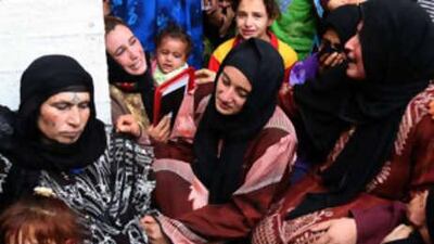 Syrians mourn slain relatives yesterday near al Sukkari farm, on the Syria-Iraq border, following the strike.