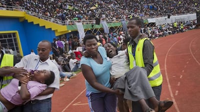 Two wailing and distraught Rwandan women, some of the dozens overcome by grief at recalling the horror of the genocide, are carried away to receive help during a public ceremony on Monday, April 7, 2014. Ben Curtis / AP