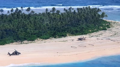 An Australian Army helicopter lands on Pikelot Island where three men were found safe and healthy after their giant SOS sign was spotted by warplanes. Australian Defence Force via AFP