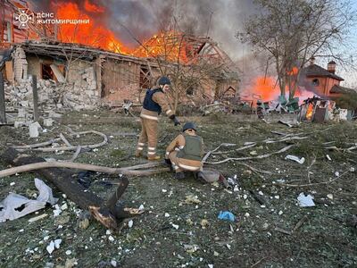 Ukrainian firefighters work near homes hit during Russian drone strikes in the north-western Zhytomyr region. Reuters