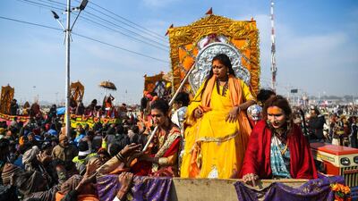 In this photograph taken on January 15, 2019, followers of the Kinnar Akhara monastic Hindu order made up of transgender members ride on a chariot in a procession towards Sangam -- the confluence of the Ganges, Yamuna and mythical Saraswati rivers -- during the auspicious bathing day of Makar Sankranti at the Kumbh Mela in Allahabad. For decades Laxmi Narayan Tripathi has fought untiringly India's conservative laws and beliefs to put her transgender community on a par with the rest of society, and now she has notched up a new milestone. On January 15 she and dozens of other resplendent "Kinnars" splashed in the sacred waters of the Ganga and Yamuna rivers alongside top Hindu ascetics at the immense Kumbh Mela festival in northern India. - / AFP / CHANDAN KHANNA