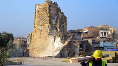 An Iraqi worker carries wood logs during the reconstruction of the "Al-Hadba" leaning minaret in Mosul’s war-ravaged old town. AFP