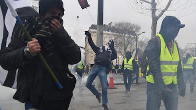 A protestor sends back a tear gas canister near the Arc de Triomphe in Paris on December 8, 2018. AFP