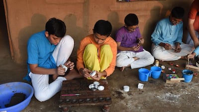 In this picture taken on October 18, 2019 boys at Gotirth Vidyapeeth, a school for Hindu and vedic teachings, make cow dung patties in preparation to make them into small oil lamps to be used in the upcoming Hindu festival of Diwali, or Festival of Lights, in Ahmedabad. AFP