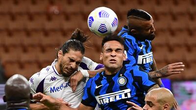 Fiorentina's Martin Caceres, left, challenges Lautaro Martinez and Arturo Vidal, of Inter, for a header in the Serie A clash. AFP