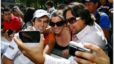 Sergio Perez, left, has not even started a Formula One race, but he is much more in demand by fans of F1. Above he poses for pictures with spectators at an exhibition at Guadalajara in Mexico. Perez makes his debut in Australia on Sunday. David Leah / Mexsport