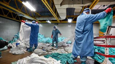 Workers handle dirty laundry from the Covid-19 zone, in the laundry room of the Mexican Institute of Social Security in Mexico City. AFP