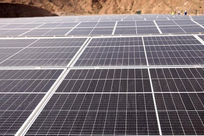 An engineer walks past solar panels at an Adnoc facility in Fujairah. AFP