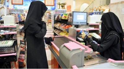 A woman cashier serves a customer at a supermarket in the coastal city of Jeddah, Saudi Arabia.
