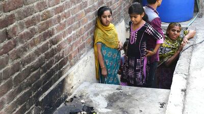 Maham and Muskan, two girls who were taught how to read the Quran by Zeenat Bibi, a 16-year-old girl who was burnt to death by her mother for marrying someone of her choice, staring in shock at the spot where their teacher was killed. The girls returned home frightened and confused, according to their families. Arif Ali / AFP