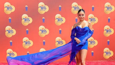 Vanessa Hudgens in a blue mini-dress with a statement train. AFP