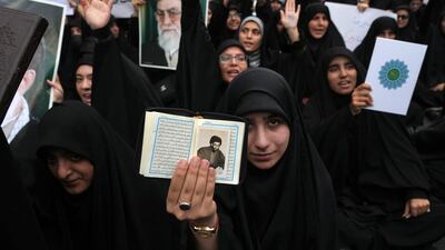 A demonstrator holds up the Quran and a portrait of Iranian supreme leader Ayatollah Ali Khamenei in a protest against Sweden in front of the Swedish embassy in Tehran. AP