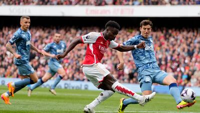 Arsenal's Bukayo Saka, left, shoots as he is closed down by Aston Villa's Pau Torres. AP