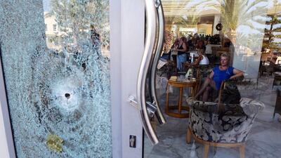 A woman looks toward a glass door shattered by a bullet at Imperial Marhaba Hotel in the resort town of Al Sousse, a popular tourist destination in Tunisia. Mohamed Messara / EPA