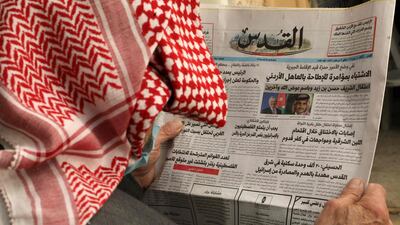 A Palestinian man reads the daily newspaper 'Al-Quds', with its front page headlines on events in neighbouring Jordan, in the occupied West Bank town of Hebron. AFP