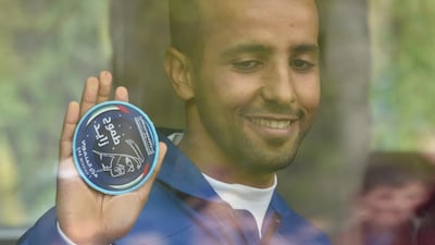 Hazza Al Mansouri holds up the Mohammed bin Rashid Space Centre crest. mission. AFP