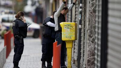 A resident is being searched by police officers in the Paris suburb of Saint-Denis. Explosions and gunfire rang out early Wednesday as heavily armed police surrounded a suburban Paris apartment in a raid targeting the suspected mastermind of last week’s Paris attacks. Peter Dejong / AP