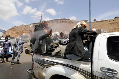 A health worker sprays disinfectant on people riding on the back of a pick up truck. Reuters