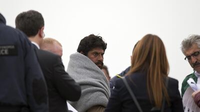 Turkish interior ministry employees in Lesbos, Greece, check the documents of a Pakistani migrant before he boards a ferry for Turkey. Petros Giannakouris / AP Photo