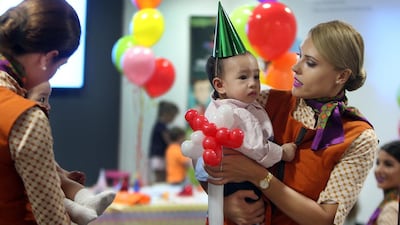 Etihad Airways nanny Slava Pavets shows her skills by entertaining 11-month-old Jariel Neal during the launch of its Etihad Explorers, which will feature Flying Nanny and Etihad Explorer kits for children. Delores Johnson / The National