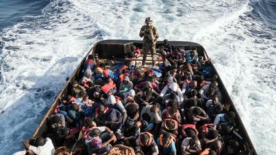 A Libyan coast guardsman stands on a boat during the rescue of 147 illegal immigrants attempting to reach Europe off the coastal town of Zawiyah, 45 kilometres west of the capital Tripoli, last June. Thousands have attempted the perilous journey in the last three years. Taha Jawashi / AFP