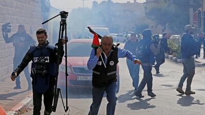 Palestinian journalists react to a stun grenade fired by Israeli forces during a protest in Bethlehem. Reuters