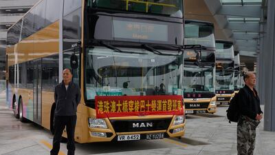 Passengers pose for a photograph in front of one of the shuttle buses. AP Photo