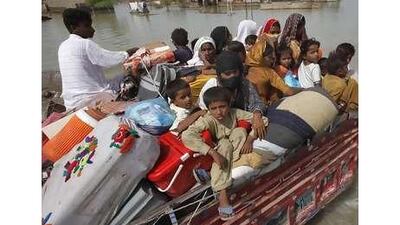 A family of flood victims transport their belongings as they return to the village of Sultan Kot in Pakistan's Sindh province.
