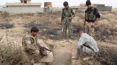 Turkmen militiamen are pictured at the entrance to a drainage tunnel in the Iraqi town of Bashir that was used by ISIL fighters to hide from coalition air strikes.