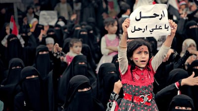 A girl holds a sign reading “Leave, Ali, Leave” in Karama Has No Walls. Courtesy Sara Ishaq