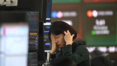 A dealer reacts as she monitors exchange rates in a foreign exchange dealing room at the Hana Bank in Seoul on Monday. South Korea's benchmark index Kospi tumbled more than 5 per cent on the day. AFP