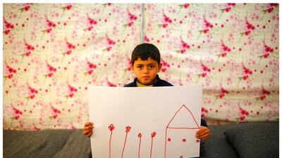 Syrian refugee Ali Addahar, 9, as he shows a drawing of his home in Syria, as he sits in his tent in Midyat refugee camp in Mardin province, Turkey.
