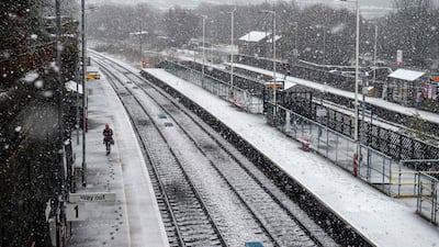 A woman walks along the platform of the railway station as snow falls in the village of Marsden, near Manchester. AFP