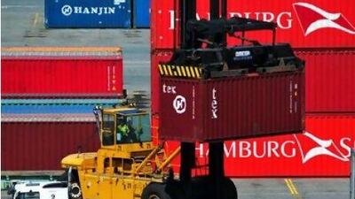 A shipping container at DP World's container berth in Australia is loaded onto a truck.