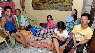 Rosalie Cabenan, second left with her husband Danilo, left, pose with some of their children at their home in Manila.