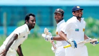 Sri Lankan batsmen Tillakaratne Dilshan, right, and Kumar Sangakkara, centre, run between the wickets as Bangladeshi cricketer Elias Sunny looks on during the final day of the opening Test match between Sri Lanka and Bangladesh on Tuesday. Lakruwan Wanniarachchi / AFP