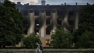 A man walks past a college on fire after a strike in Lysychansk in the eastern Ukrainian region of Donbas. AFP