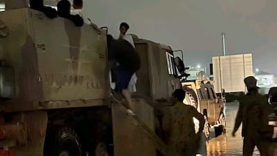 Servicemen transport families from their flood-affected homes to safety.