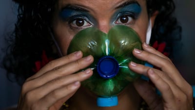 Actress Thais Bezerra puts on a mask made from a plastic bottle as she gets dressed in her costume to perform in a video recording of 'Giant Dreamers' outside the Museum of Modern Art during the Covid-19 pandemic in Rio de Janeiro, Brazil. AP Photo